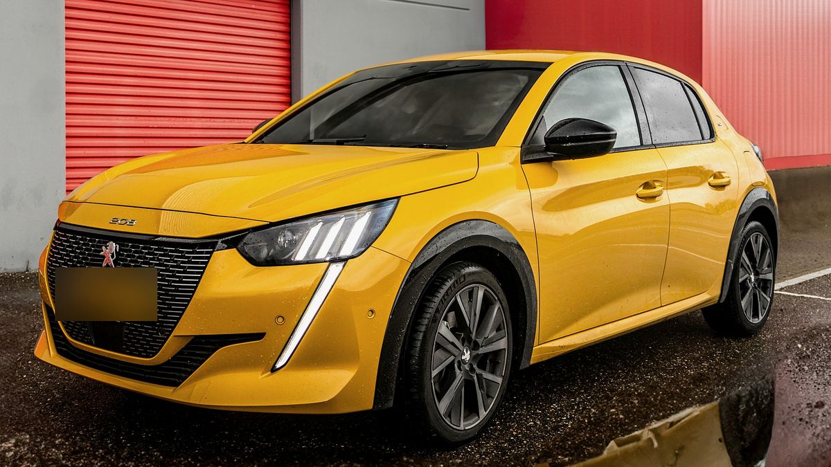 Gul Peugeot 208 parkeret foran en erhvervshal — annoncebillede